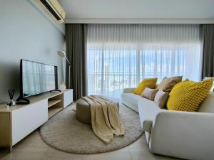 a living room with a white couch and a television at 2 Bedroom Condo R258 Veranda Pattaya Beachfront in Na Jomtien