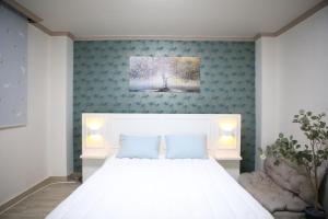 a bedroom with a white bed and a blue wall at Daegu Room new open 4 RoomPrivate Villa in Daegu
