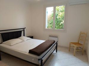 a bedroom with a bed and a chair and a window at Superbe villa T4 classée 3 étoiles avec piscine privative chauffée 8PALCR in Saint Cyprien Plage