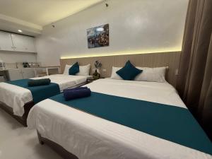 Un dormitorio con dos camas con almohadas azules. en Touristation @ Crowne Bay Tower, en Manila