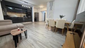 a living room with a couch and a table and chairs at City Place Luxury in Târgovişte