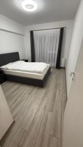une chambre avec un lit et un parquet dans l'établissement City Place Luxury, à Târgovişte