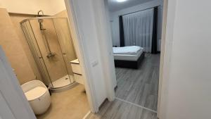 une salle de bain avec toilettes et douche et un lit dans l'établissement City Place Luxury, à Târgovişte 13 autres photos