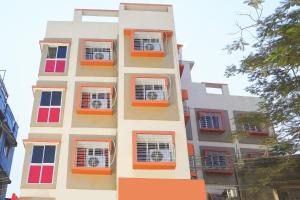 an apartment building with red windows andanimal cages at Hotel O Barman Guest House in Kolkata