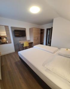 Una habitación de hotel con dos camas y un escritorio. en Gasthof Sonne, en Altach
