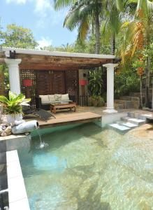 a swimming pool with a patio and a house at Bois Joli in Mahe
