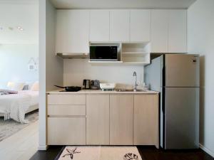 a kitchen with a refrigerator and a microwave at 2 Bedroom Condo R268 Veranda Pattaya Beachfront in Na Jomtien