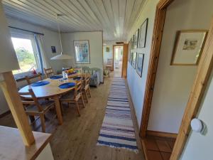 a dining room and living room with a table and chairs at Boende på SydKoster med havsutsikt och nära till bryggor in Strömstad