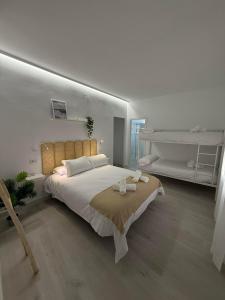 una camera da letto con un grande letto bianco con cuscini bianchi di La Posada a Úbeda