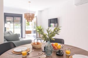 a table with a vase of flowers and fruit on it at Lagune apartment in Santiago de la Ribera