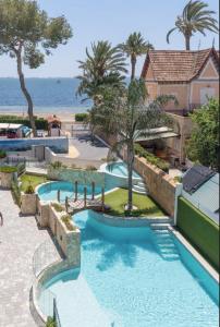a resort with two swimming pools and the ocean at Lagune apartment in Santiago de la Ribera