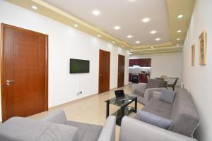 a living room with couches and a table and a tv at Stylish 3 room ap near republic square in Yerevan