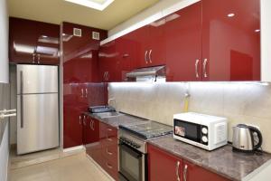 a kitchen with red cabinets and a white microwave at Stylish 3 room ap near republic square in Yerevan