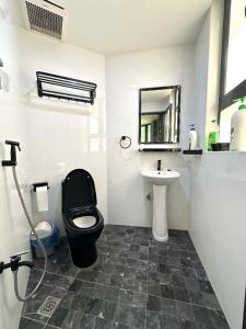ein Badezimmer mit einer schwarzen Toilette und einem Waschbecken in der Unterkunft Jovial Boutique Hotel```` Kampung Baru in Bukit Mertajam + 19 Fotos