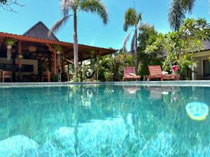 a swimming pool in front of a house at Elisa Hostel in Kuta Lombok