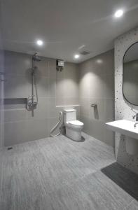 a bathroom with a toilet and a sink and a mirror at Rosewood Sridaan in Ban Khlong Samrong