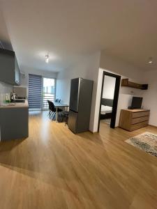 a kitchen and a living room with a wooden floor at London Residence Deluxe 2-Bedroom in Suceava