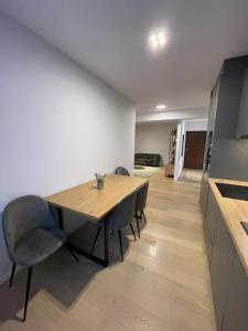 a dining room with a wooden table and chairs at London Residence Deluxe 2-Bedroom in Suceava