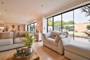 a living room with two couches and large windows at Modern 5-Bed Retreat with Parking in Cockett +30 photos