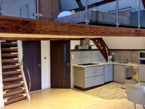 a loft bed in a room with a kitchen at Historic Canal-Side Apartment in Schiedam