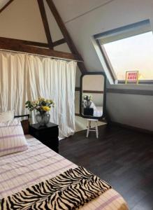 a bedroom with a bed and a window and a mirror at Historic Canal-Side Apartment in Schiedam