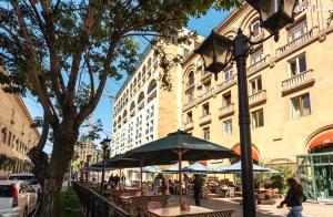 a group of tables and umbrellas in front of a building at Stylish 3 room ap near republic square in Yerevan