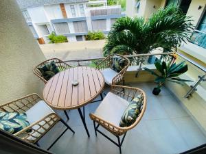 a patio with a table and chairs on a balcony at Apartment Ocean Legend Tamarin in Tamarin