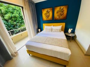 a bedroom with a bed and a large window at Apartment Ocean Legend Tamarin in Tamarin