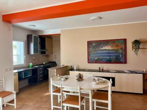 a kitchen with a white table and chairs in a room at San Lorenzo Beach in Marina di San Lorenzo +20 photos