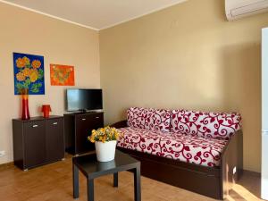 a living room with a couch and a tv at San Lorenzo Beach in Marina di San Lorenzo