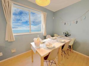 ein Esszimmer mit einem Tisch und einem großen Fenster in der Unterkunft The feel Kincho cho Seaside villa - sea - / Vacation STAY 26185 in Yaka
