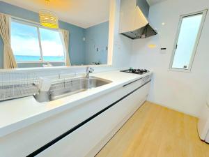 eine Küche mit Spüle und Fenster in der Unterkunft The feel Kincho cho Seaside villa - sea - / Vacation STAY 26185 in Yaka + 51 Fotos