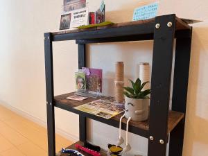 Une étagère noire avec des livres et une plante sur elle dans l'établissement Oceanview 16 IKI, à Iki