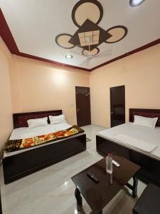 a bedroom with two beds and a ceiling fan at Shree Ramanam Palace in Ayodhya