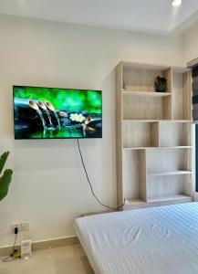 a bedroom with a flat screen tv on the wall at Shi House -Cozy 2BR, S1001 Beautiful Vinhomes Q9 in Ho Chi Minh City