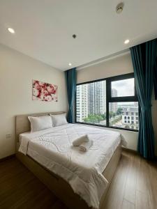 a bedroom with a large bed with a large window at Shi House -Cozy 2BR, S1001 Beautiful Vinhomes Q9 in Ho Chi Minh City
