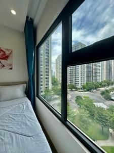 a bedroom with a window with a view of a street at Shi House -Cozy 2BR, S1001 Beautiful Vinhomes Q9 in Ho Chi Minh City