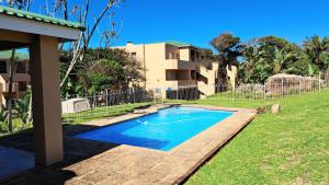 una piscina en un patio al lado de una casa en Marina Palms Unit 22, en Hibberdene
