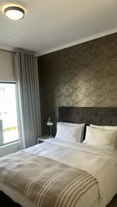a bedroom with a large bed and a window at The Sweet Serenity Suite in Midrand