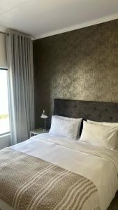 a bedroom with a large white bed and a window at The Sweet Serenity Suite in Midrand +23 photos
