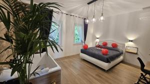 a bedroom with a bed with red pillows and a plant at Superior Suite, Villa Joy Verona, Luxury Romantic Suite with Jacuzzi, near City Center in Verona