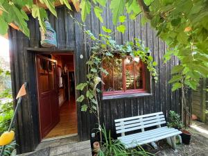 a wooden house with a bench in front of it at Authentique Chambre Cabane Cap Ferret Mimbeau in Lège-Cap-Ferret