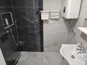 Un baño blanco con lavabo y ducha. en Room with jacuzzi and sauna Edy, en Zagreb