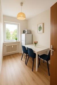 a kitchen with a table and chairs and a refrigerator at SUNNYHOME Monteurwohnungen und Apartments in Weiden in Weiden