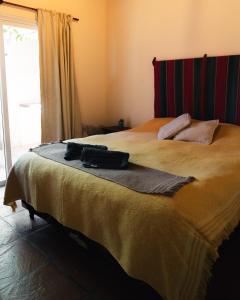 a bedroom with a bed with a bag on it at Cabañas Canto a Jujuy- acceso privado al Rio in Yala