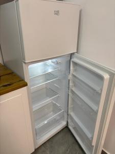 an empty refrigerator with its door open in a kitchen at Cozy Apartment Mureseni in Târgu-Mureş