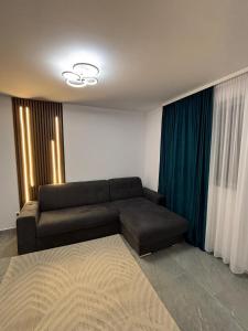 a living room with a couch and blue curtains at Cozy Apartment Mureseni in Târgu-Mureş