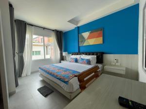 a bedroom with a blue wall and a bed at Lanta Corsica Hotel in Ko Lanta +62 photos