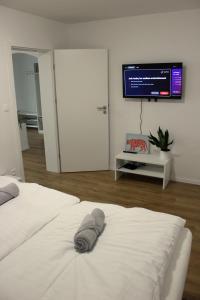 a bedroom with two white beds and a flat screen tv at KAVE Obchodná Apartments in Bratislava
