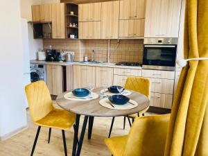 クライペダにあるApartamentai Auksinės Bangos - Free parking - Central getawayのキッチン(木製テーブル、椅子付)、ダイニングルーム